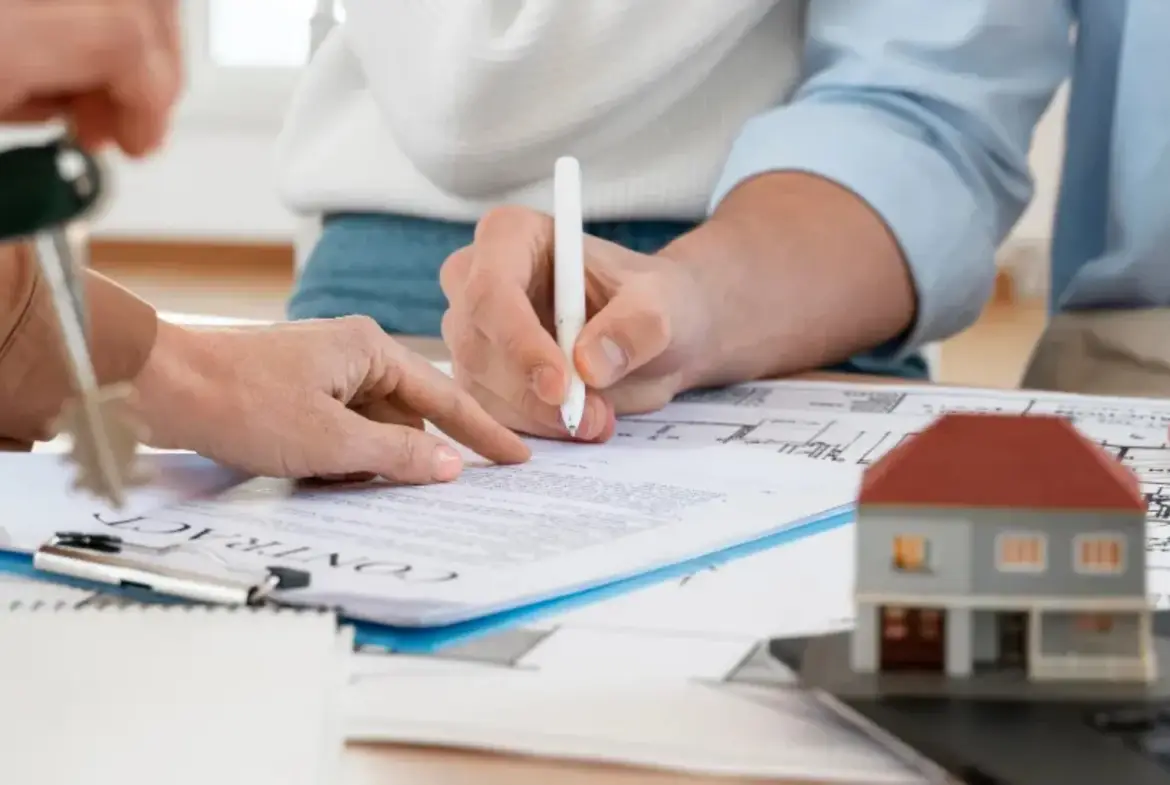 Hombre firmando un documento para cerrar un trato.