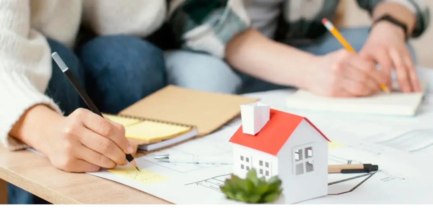Familia planificando finanzas sobre planos de vivienda.