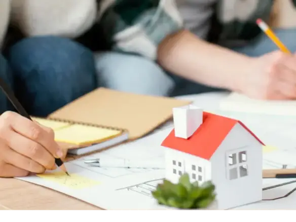 Familia planificando finanzas sobre planos de vivienda.