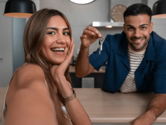 Pareja exhibiendo las llaves de la casa contentos. Leasing Habitacional