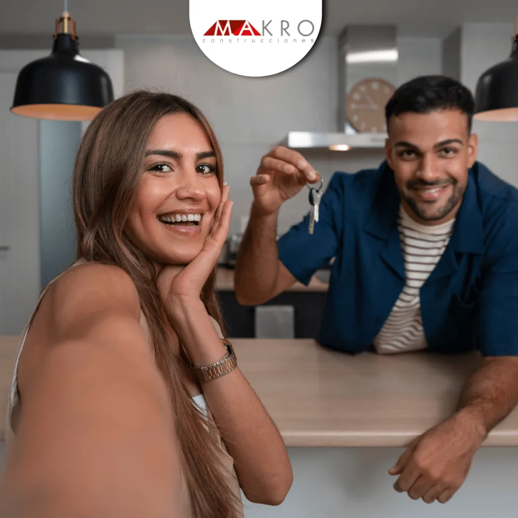 Pareja exhibiendo las llaves de la casa contentos. Leasing Habitacional